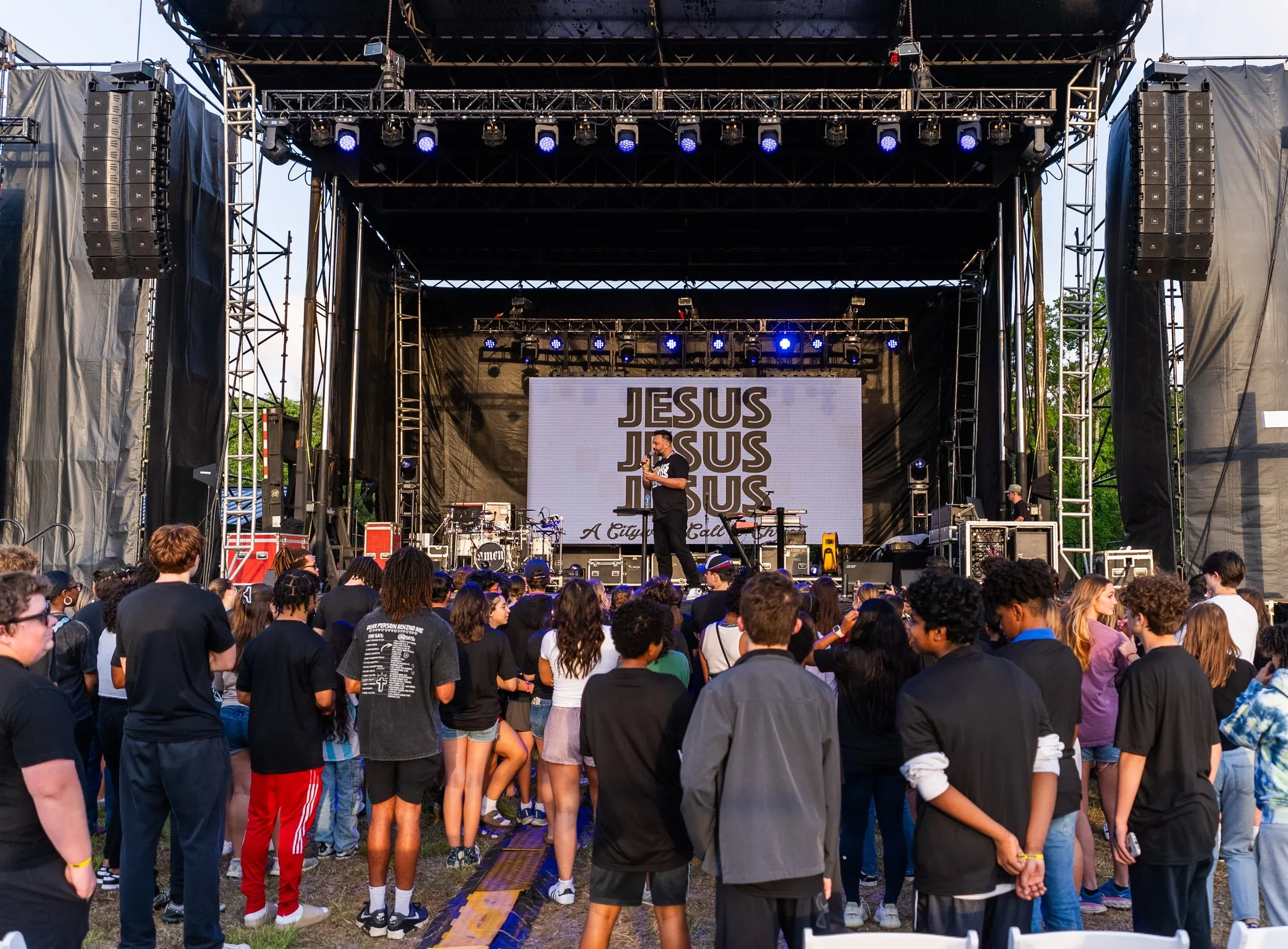 The crowd facing the stage at dusk