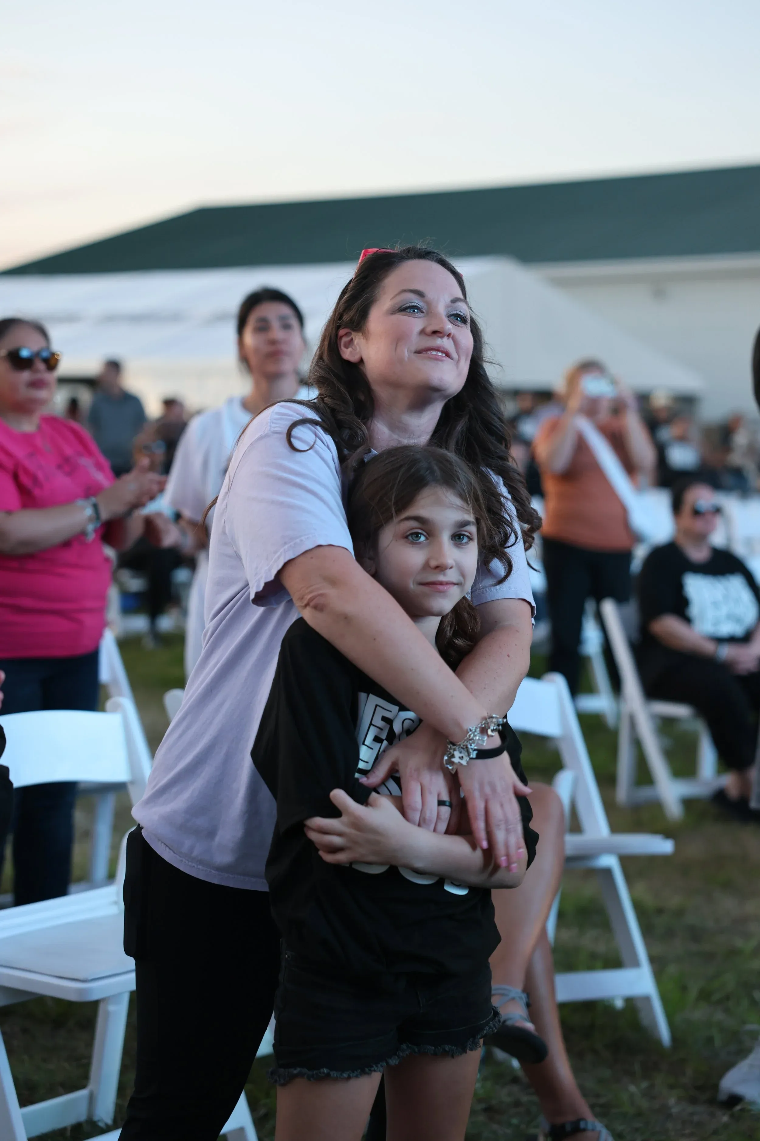 A mother holding her daughter during a night at The Field