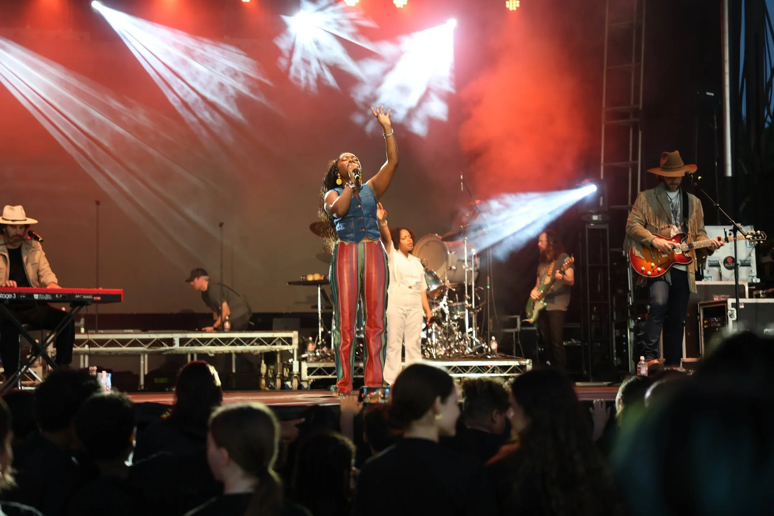 A singer on stage under white light and confetti